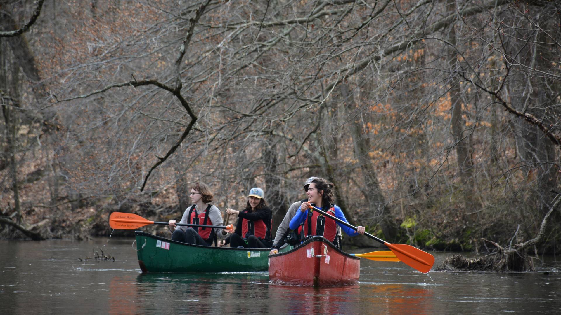 Student paddling in canoes on the Milstone River
