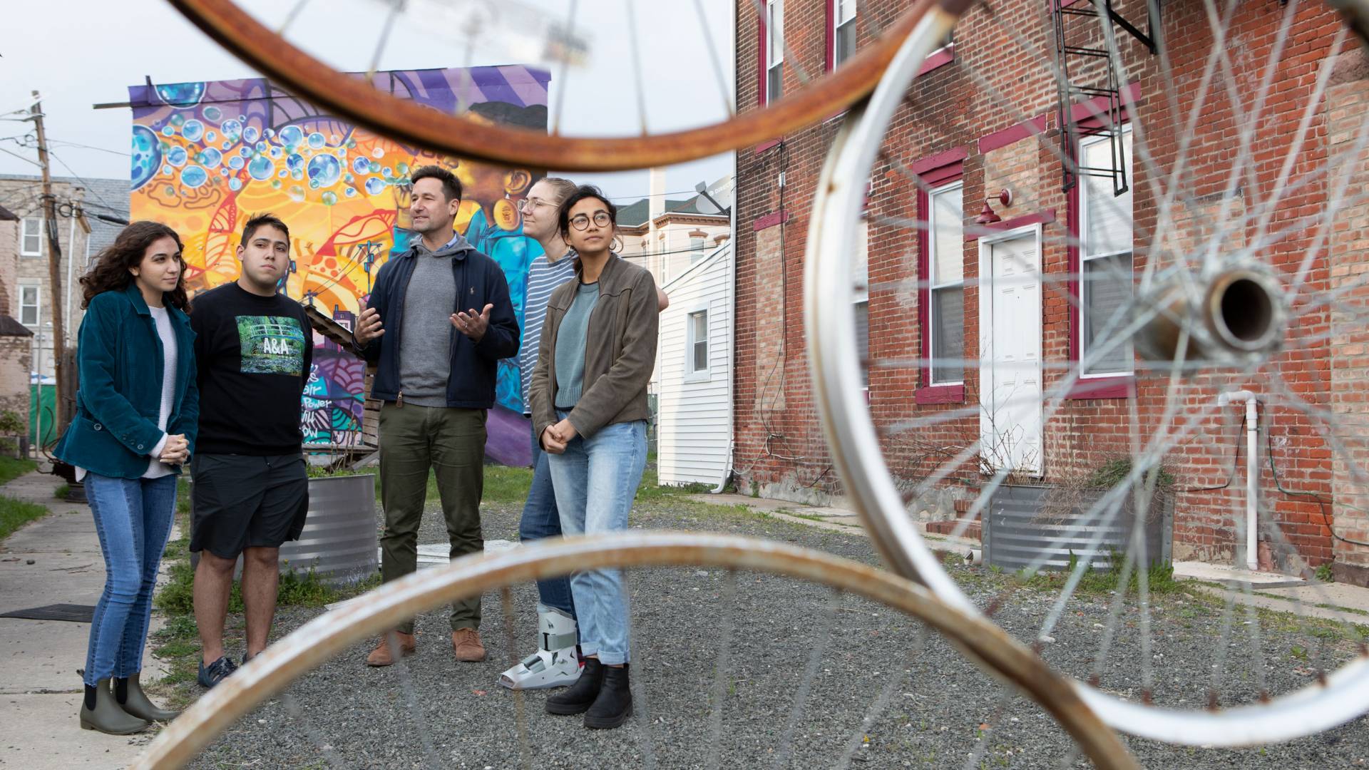 Professor Basile Baudez and students stand in an alleyway in Trenton NJ