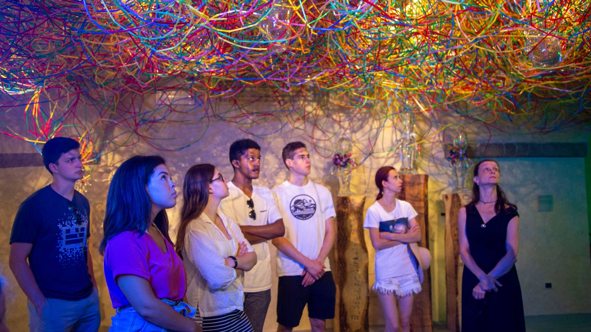 Students standing underneath art installation