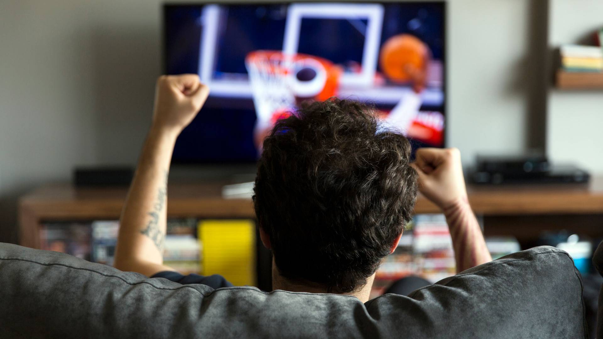 man watching basketball game on TV