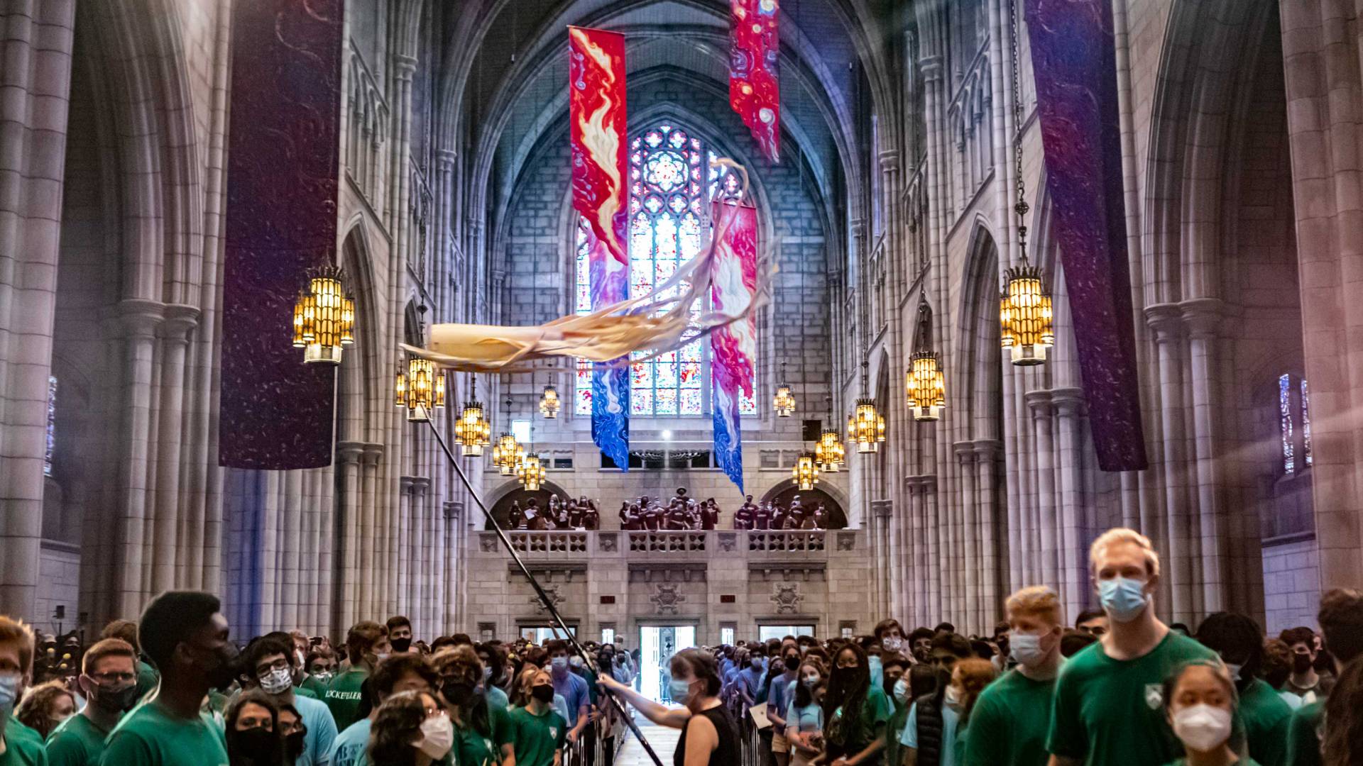 Students watch as the kite flyers walk up the chapel aisle