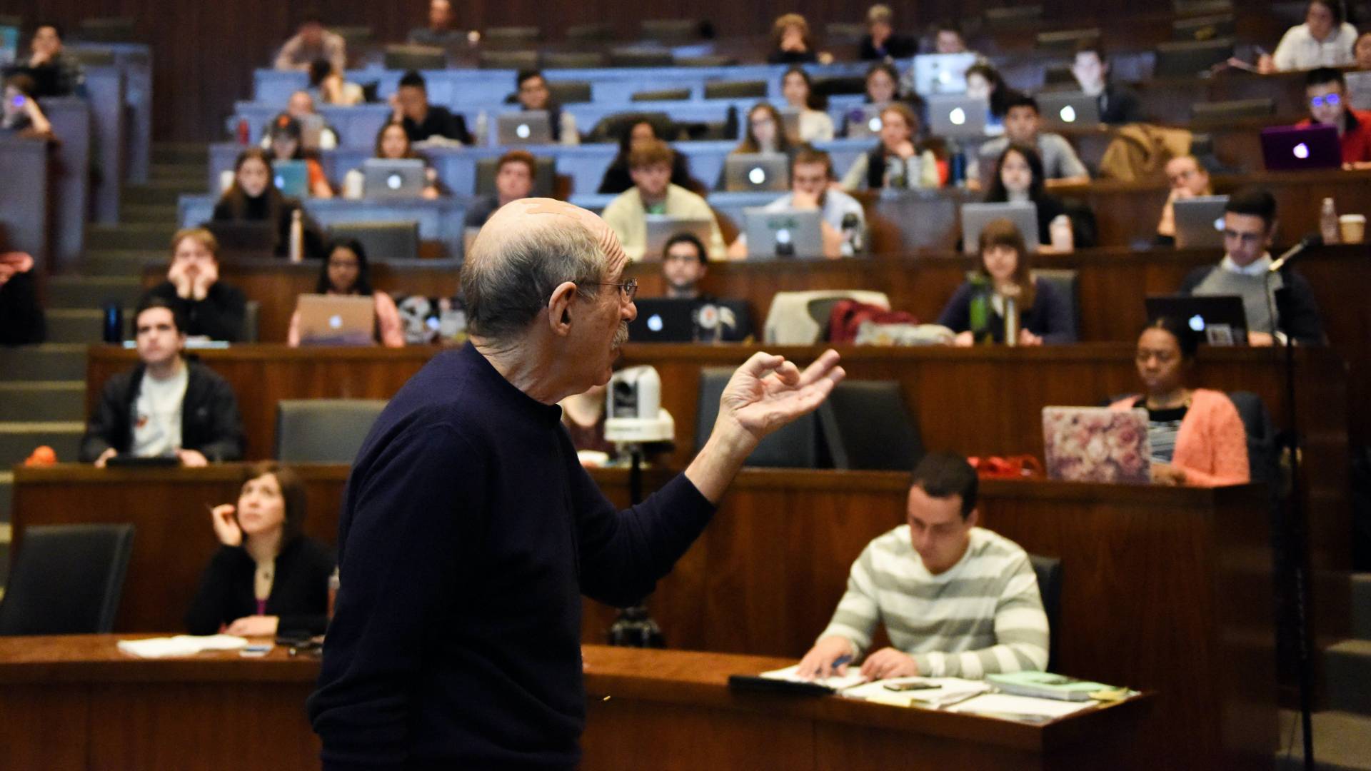 Professor Michael Oppenheimer speaking in large, tiered lecture hall