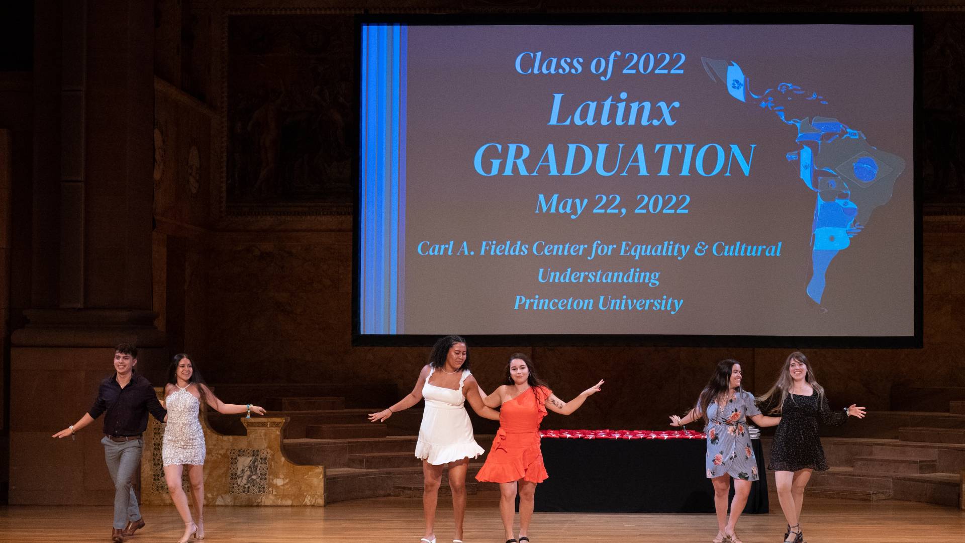 Students dance on stage at Latinx Graduation ceremony.