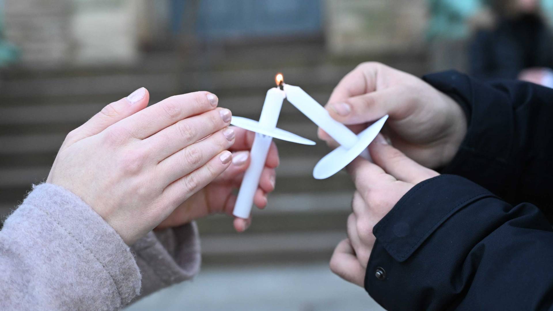 hands holding candles at a vigil