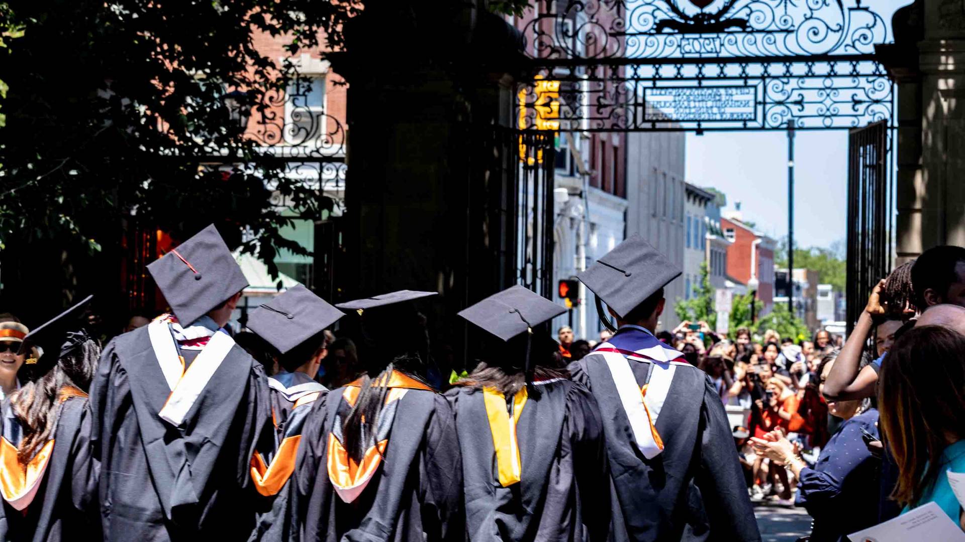 Graduating students walking towards the gate