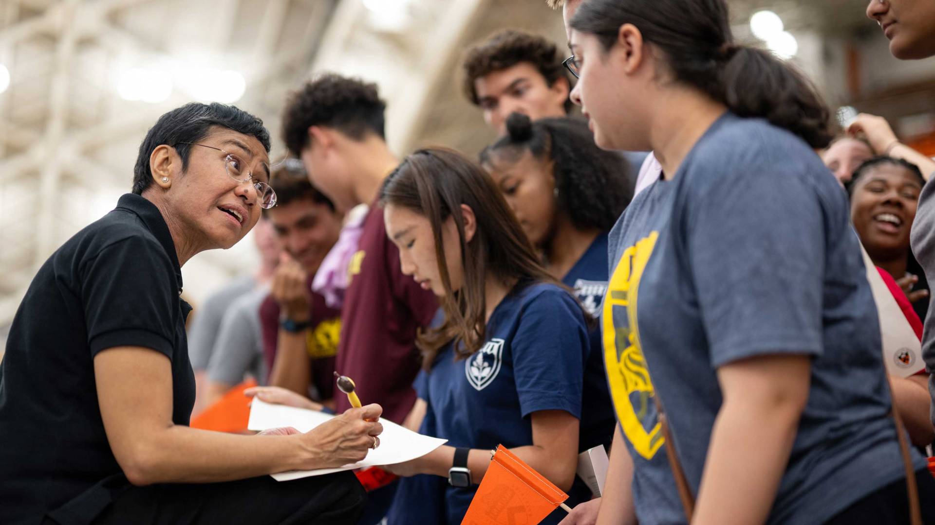 Maria Ressa signs books for students