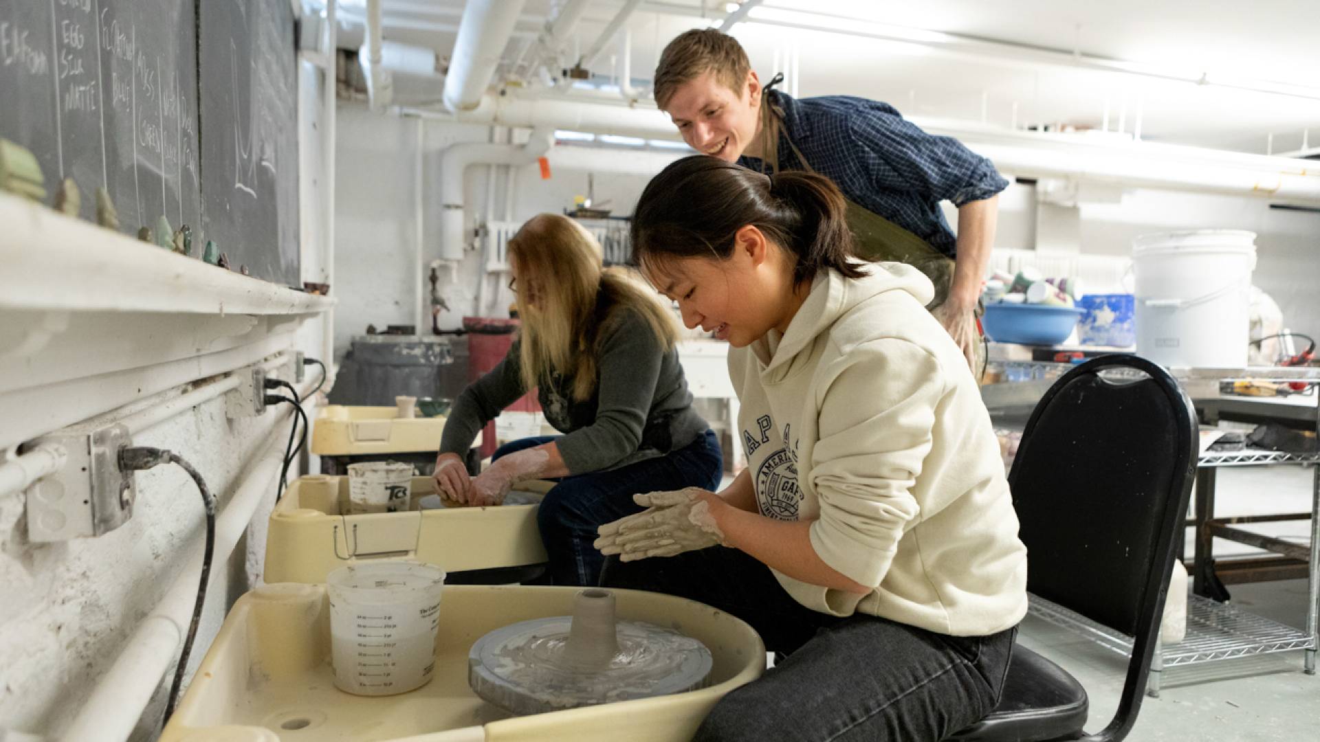 Students and staff learn to spin clay during a Wintersession pottery  class held at the Lewis Center for the Arts. 