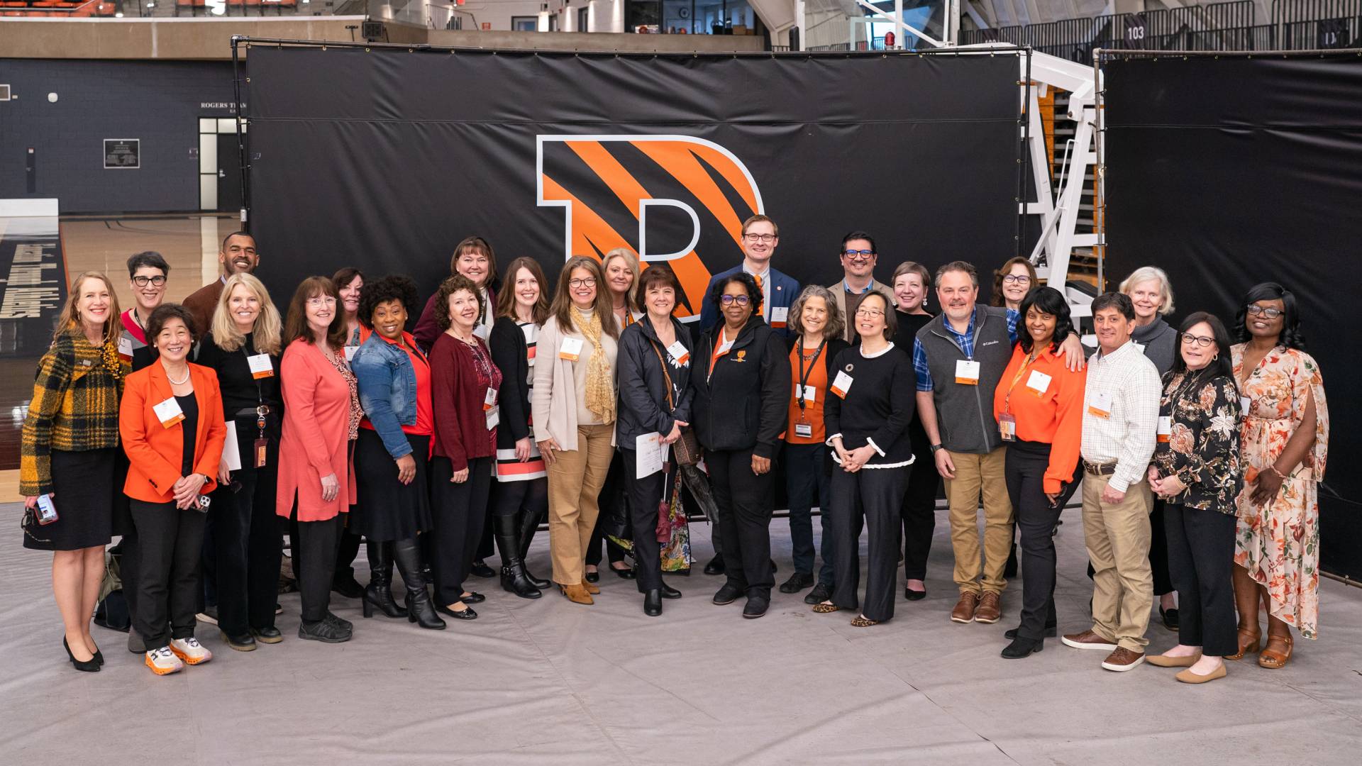 Advancement group poses in front of tiger stripe P banner