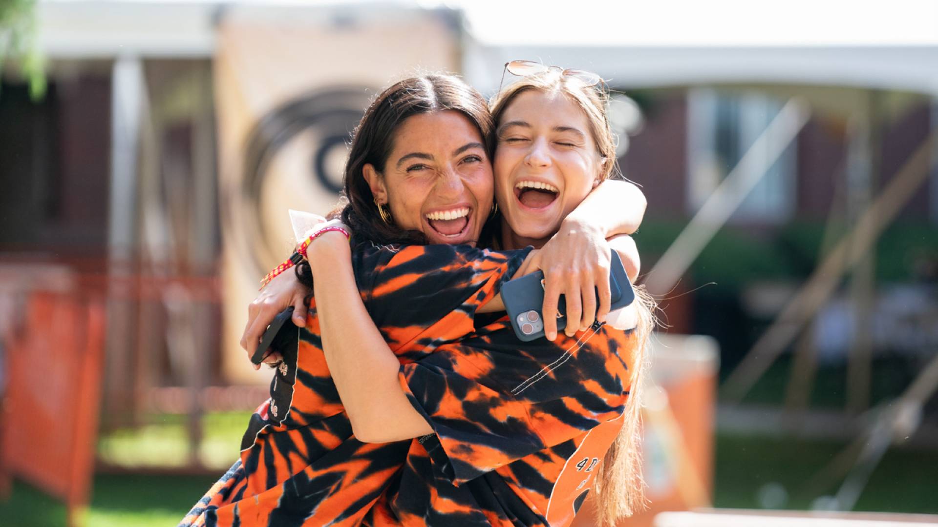 Two alumni hugging wearing tiger print shirts