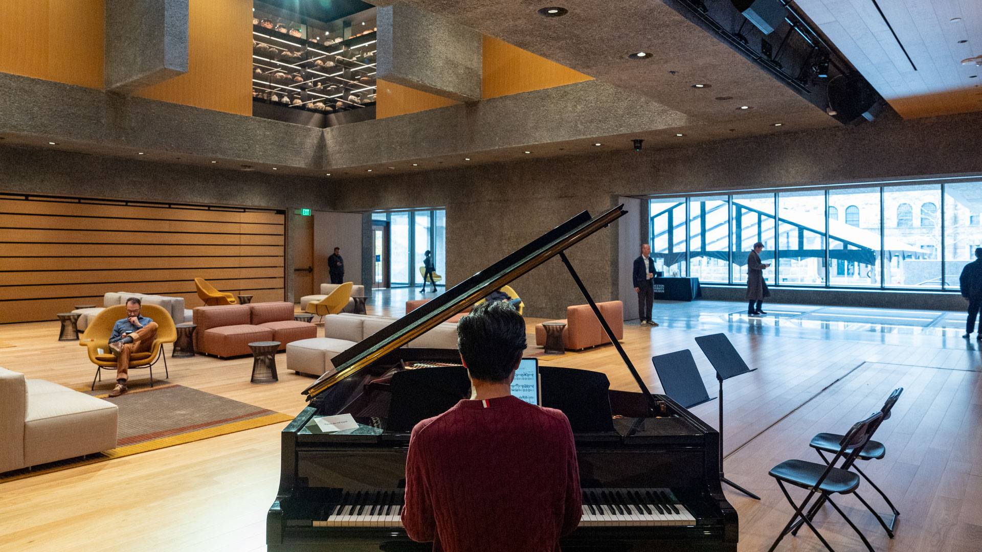 Student plays a piano in the Grand Hall