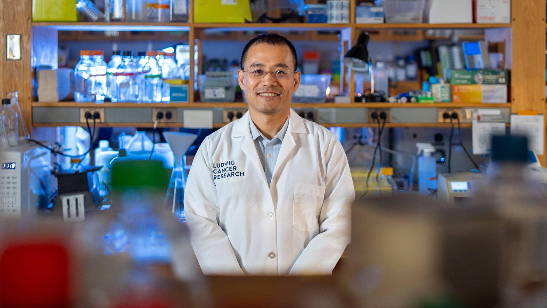 Yibin Kang smiles in his lab.