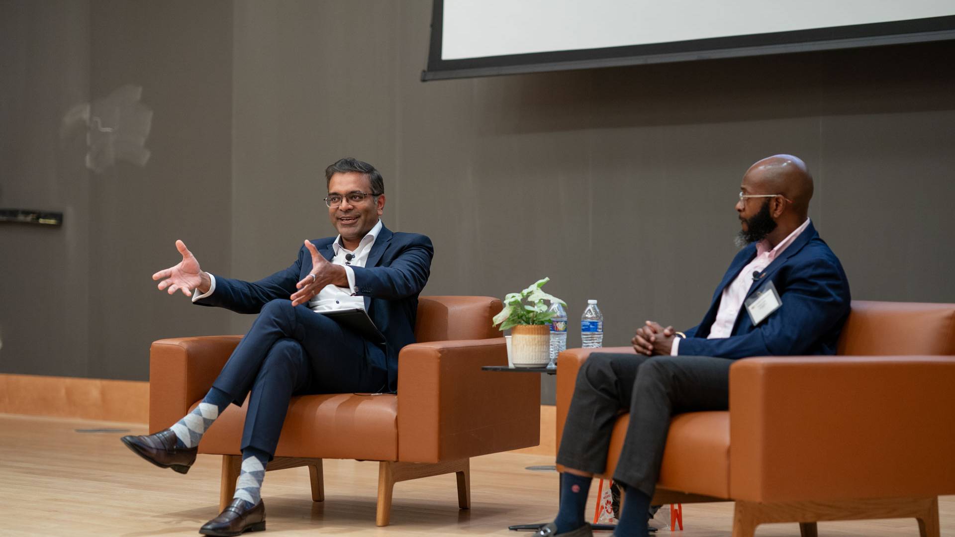 Two speakers seated onstage for a fireside chat at the Graduate Scholars Retreat