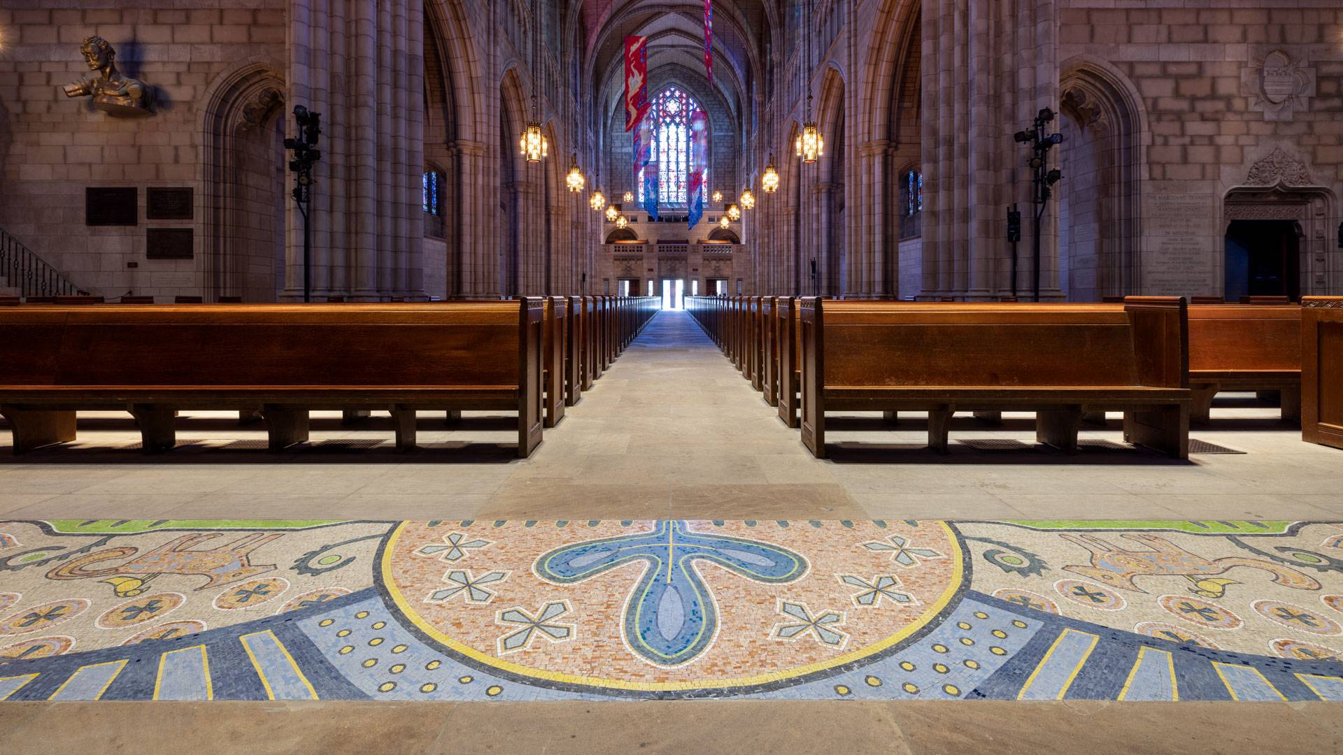 A stone mosaic along the first row of pews in the Chapel