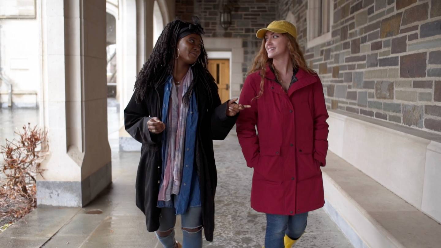 Two students walking together in breezeway