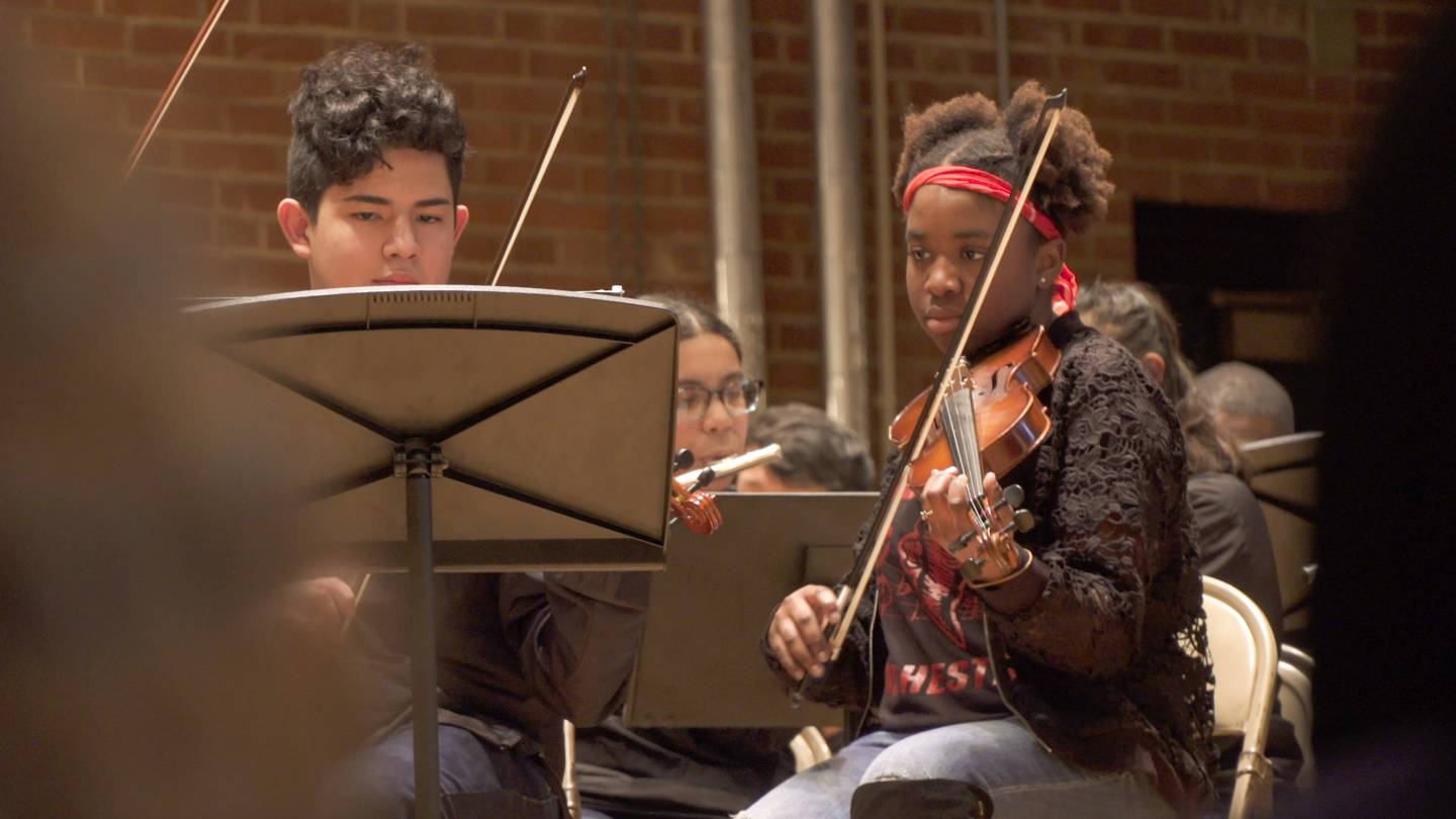Students playing the violin in small orchestra