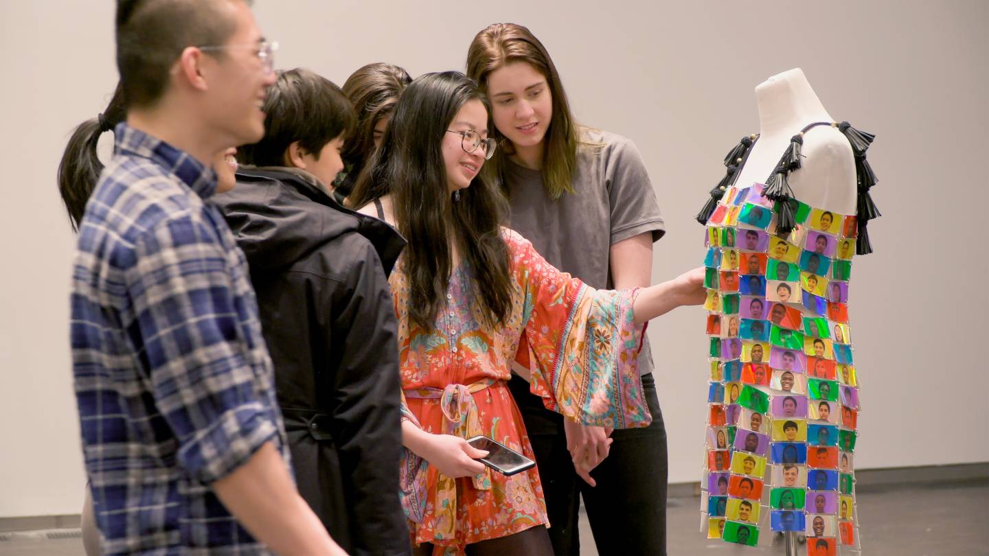Jessica Zhou (center) discusses her multi-colored "emotions" dress with a group of other students
