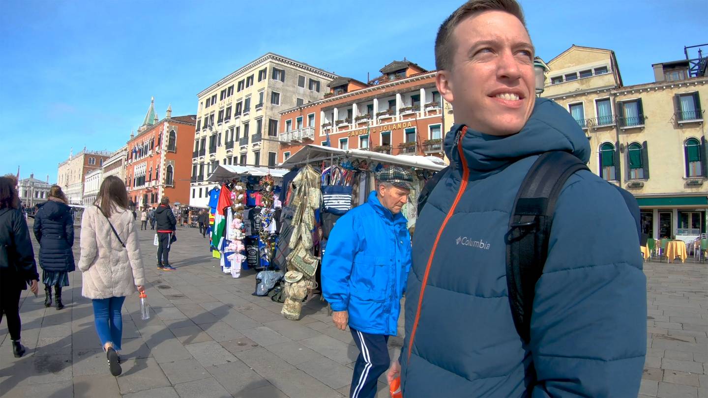 Kyle Masson looks over his shoulder on a sunny plaza in Venice, Italy