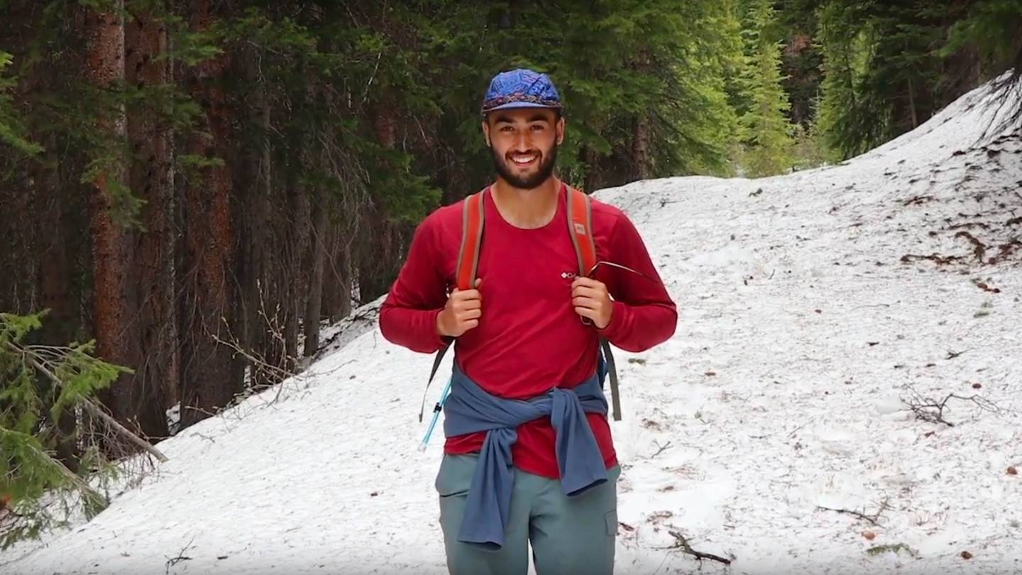 Cole stands in a snowy clearing on a hike