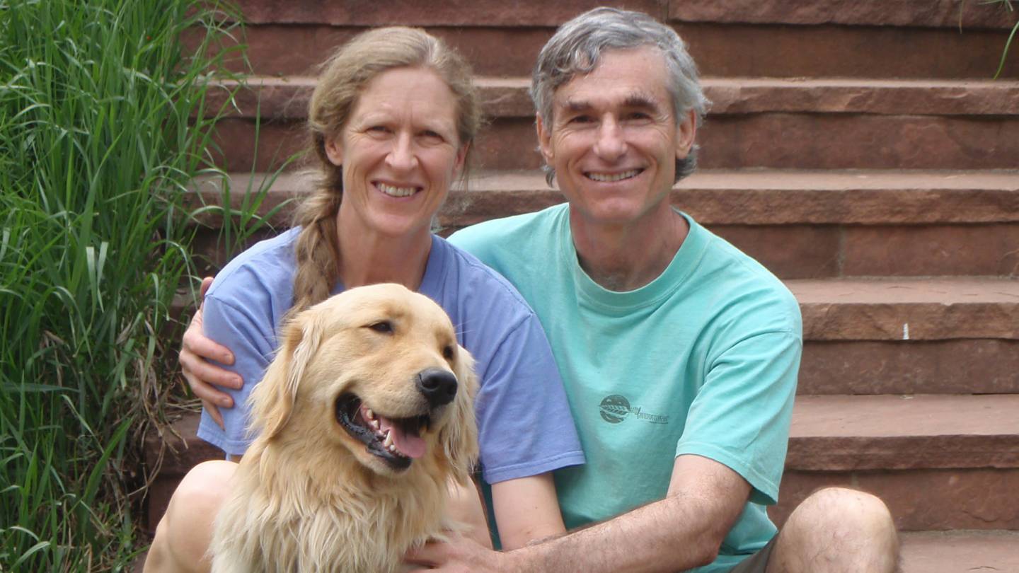 Currie and Tom Barron with a golden retriever
