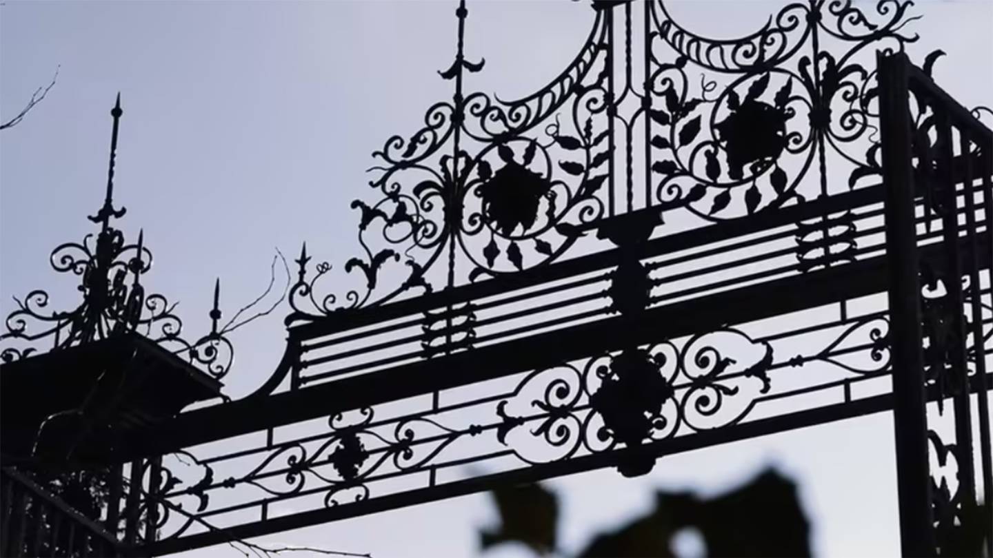 Silhouetted wrought iron of the top of the gate