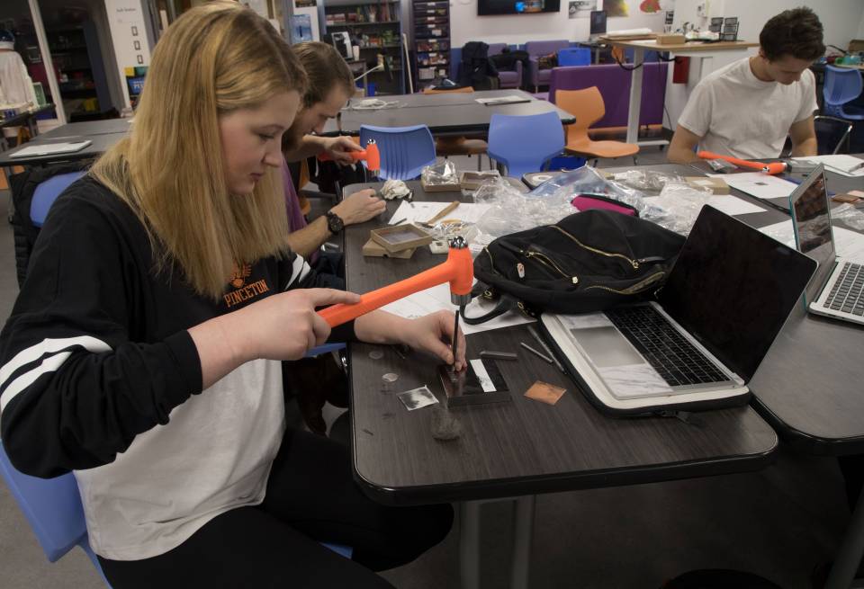 Carley Stamps using hammer to make viking-inspired jewelry