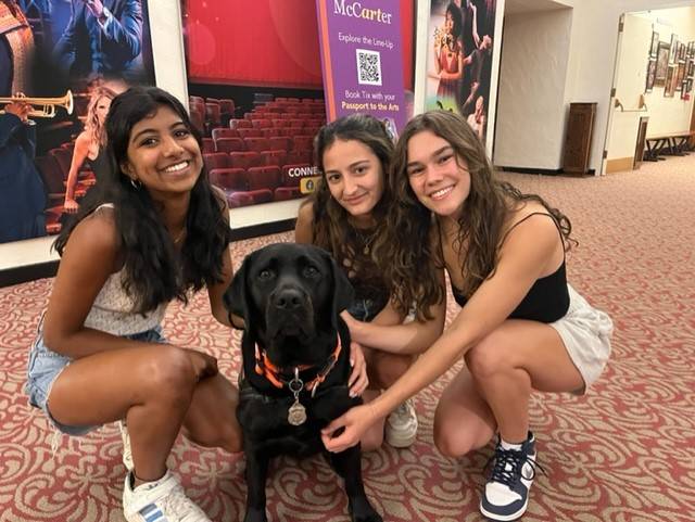Three students with Coach the dog.