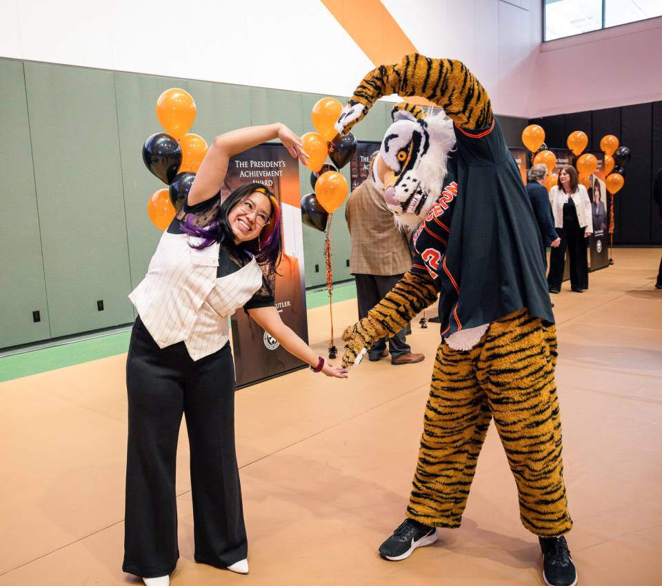 The Princeton Tiger mascot and an employee make a heart with their hands