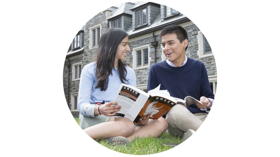 Students sitting on the lawn with books
