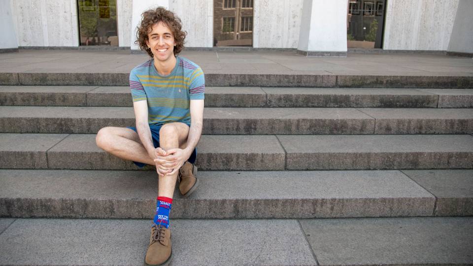 Kyle Berlin sitting on steps outside Woodrow Wilson building