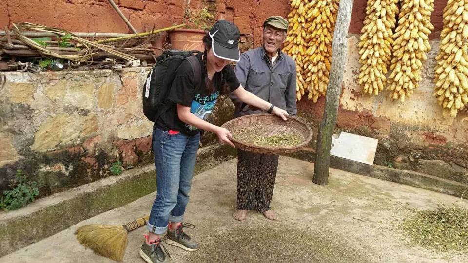 Kisara Moore sifting buckwheat in Kunming, China next to an elderly Chinese man