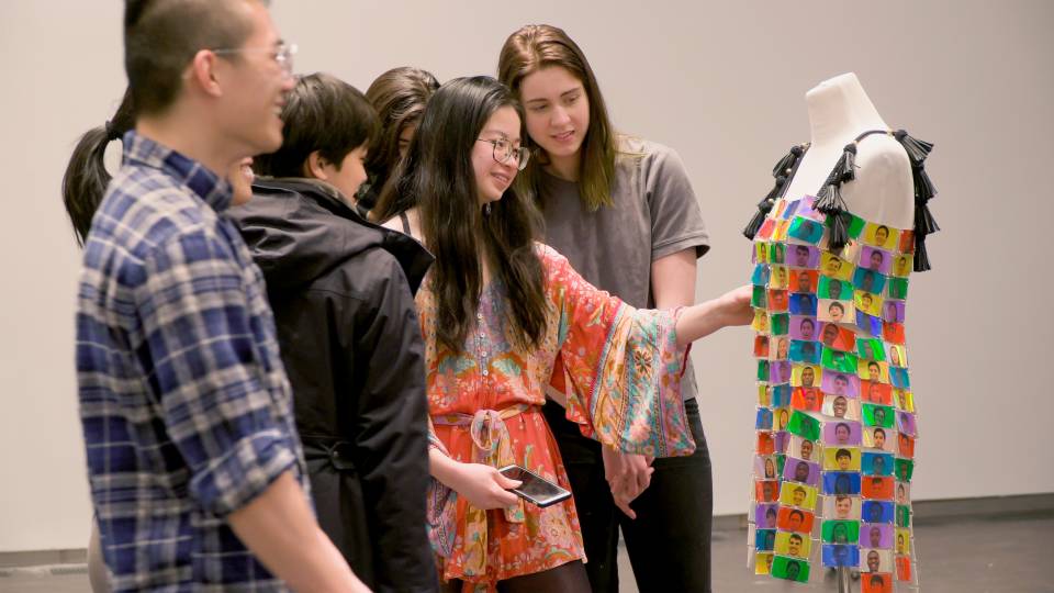 Jessica Zhou (center) discusses her multi-colored "emotions" dress with a group of other students