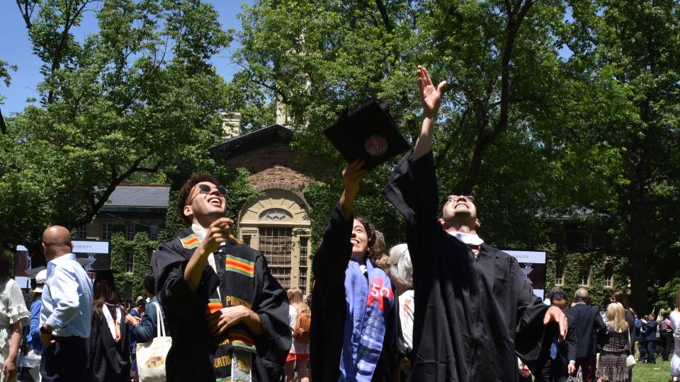 Graduates throw thier mortarboards into the air