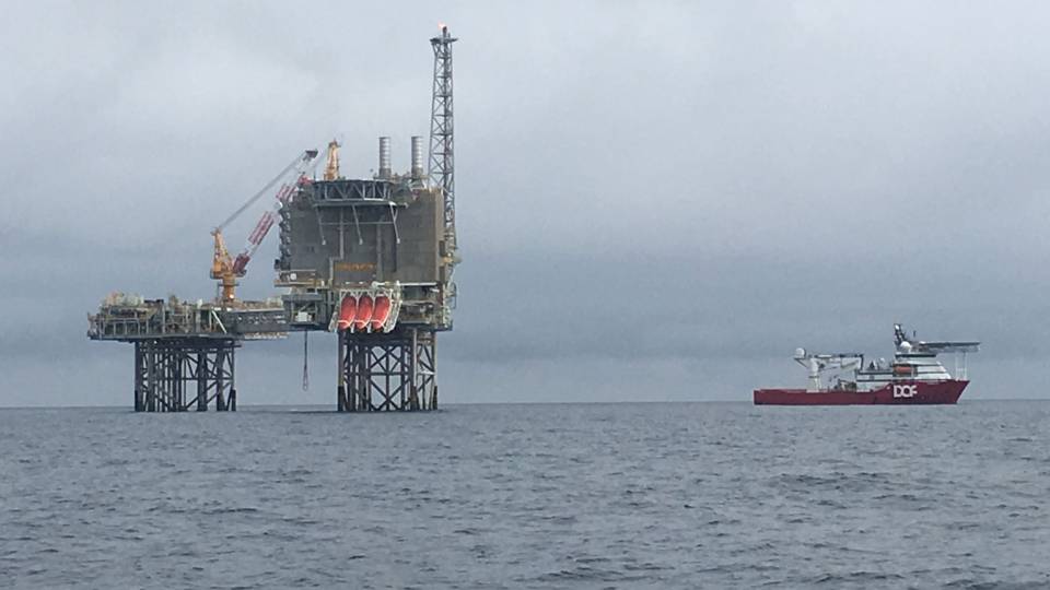 a boat and offshore oil drilling rig