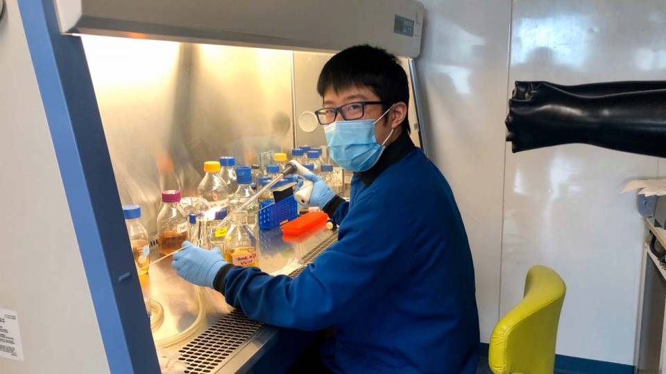 A researcher sits at a chemistry workstation