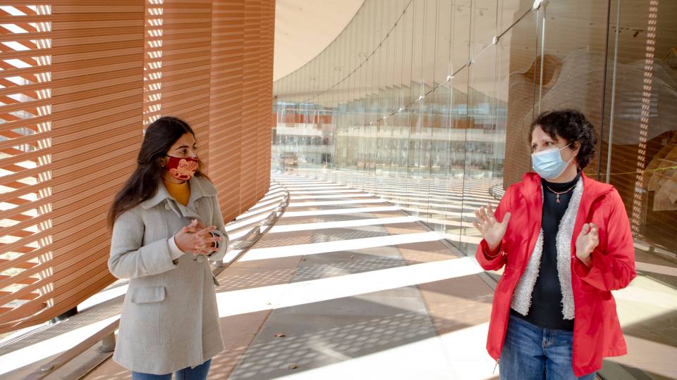 Anu Ramaswami and a student speak outdoors