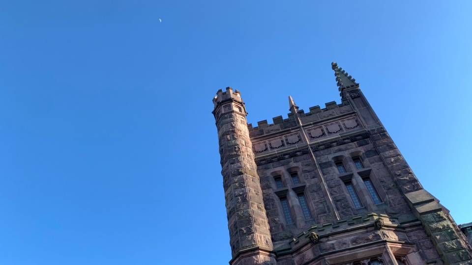 Murray-Dodge Hall with a sliver of moon in a blue sky