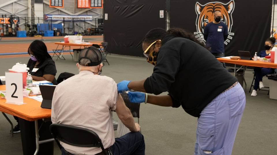 A man receives a vaccine at a University clinic