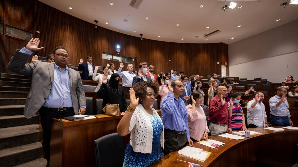 Naturalization ceremony participatns take the oath of allegiance.