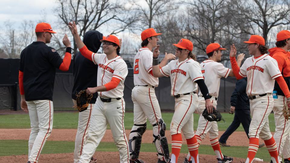 Princeton baseball players high-five one another after winning game