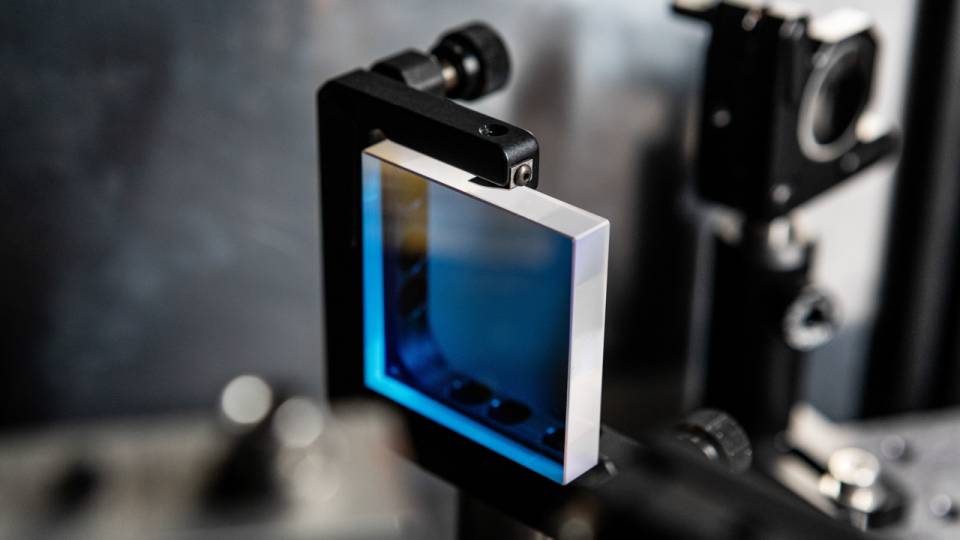A small square lens held by a black armature.