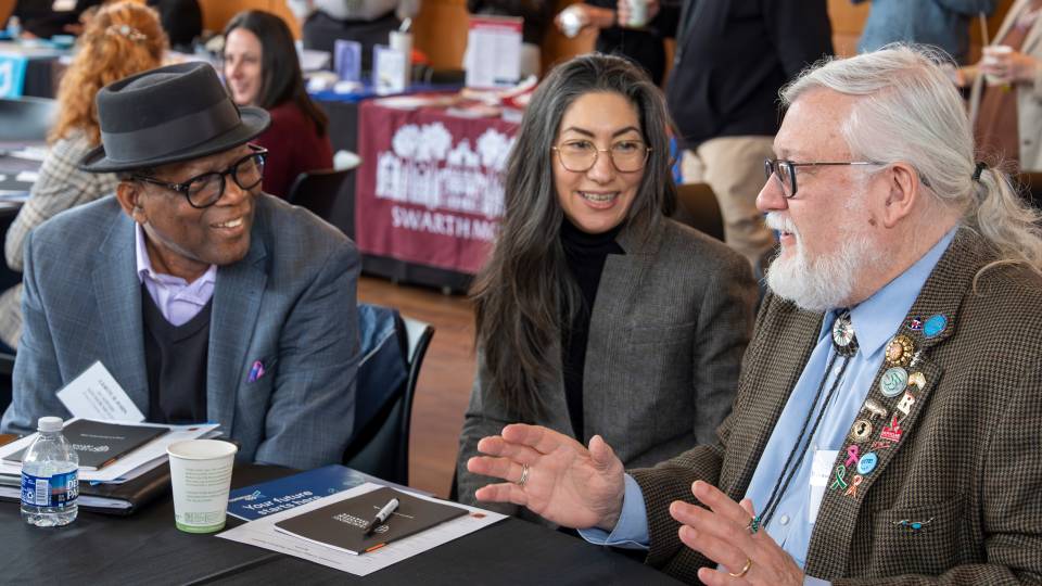 Three community college staff members talk closely with each other 