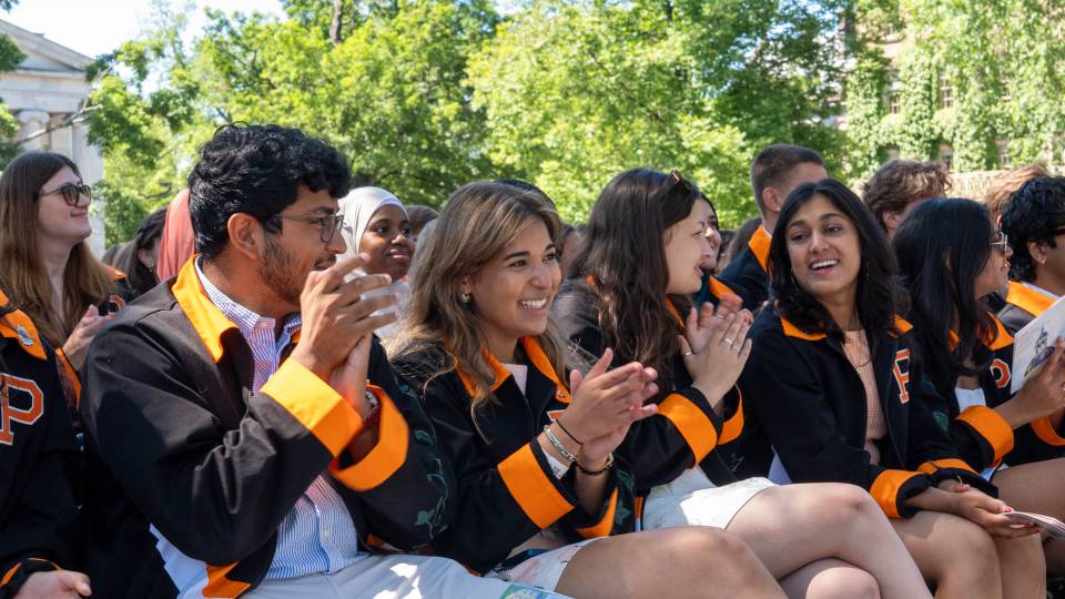 A row of students excitedly clapping their hands