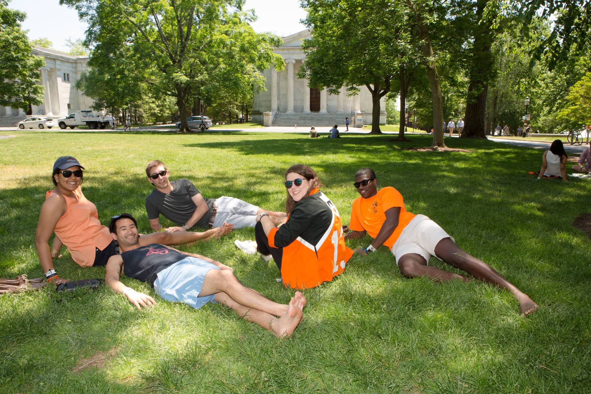 Photo of alumni lying on grass on Cannon Green.