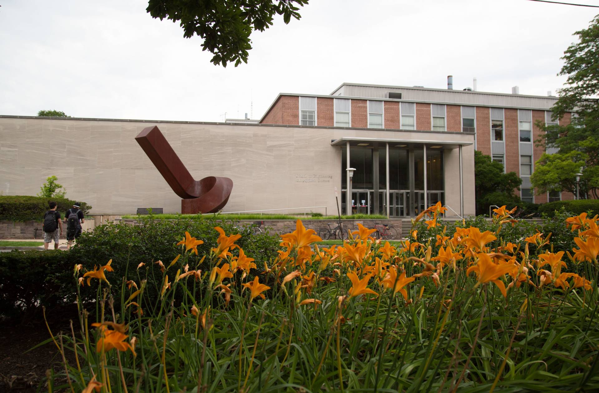 Exterior view of the engineering school, with orange flowers in the foreground.