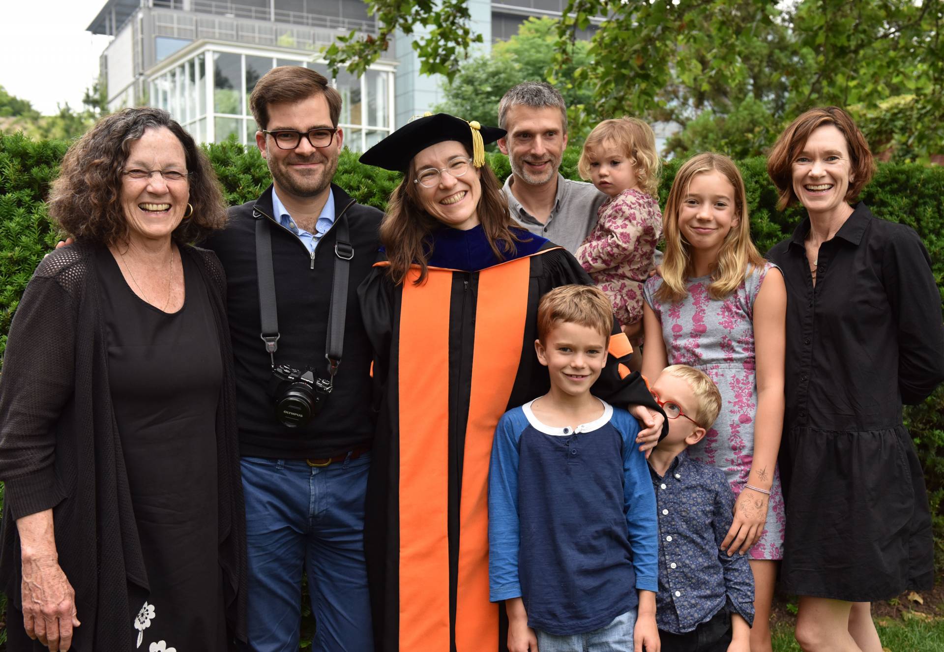 Student stands with family after ceremony