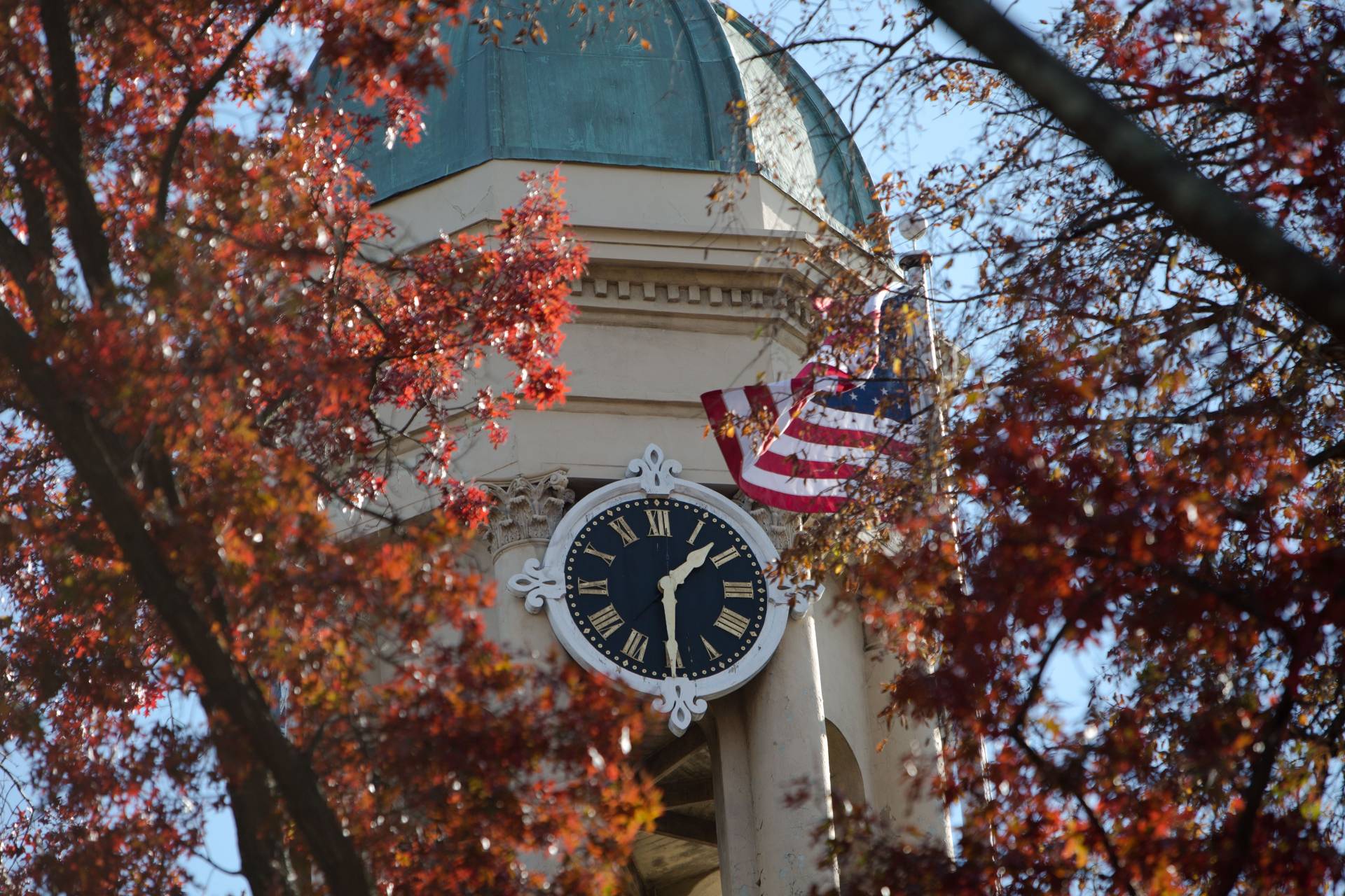The cupola of Nassau Hall showing its clock and an American flag
