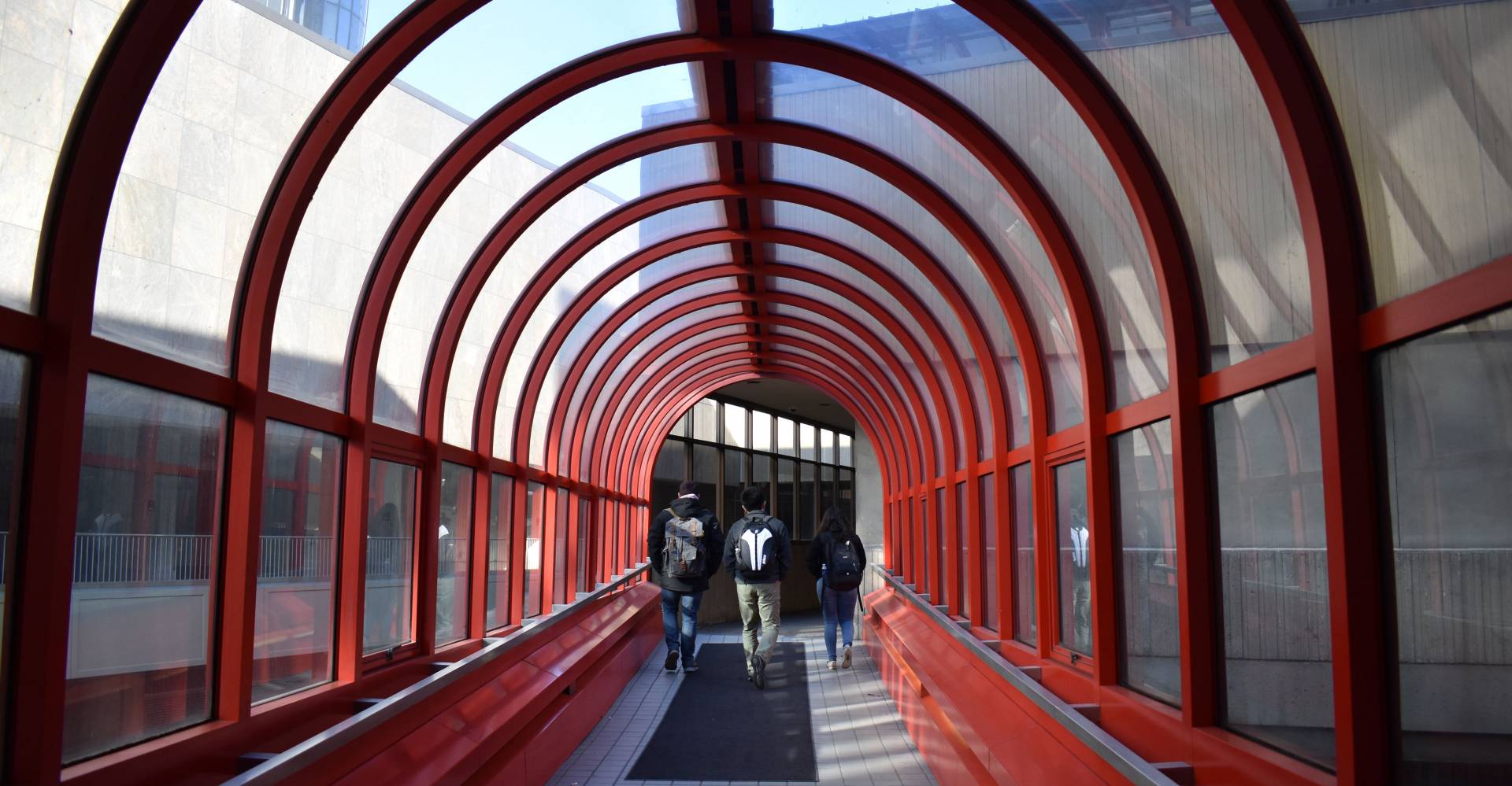 Students walking through red steel arch in Detroit