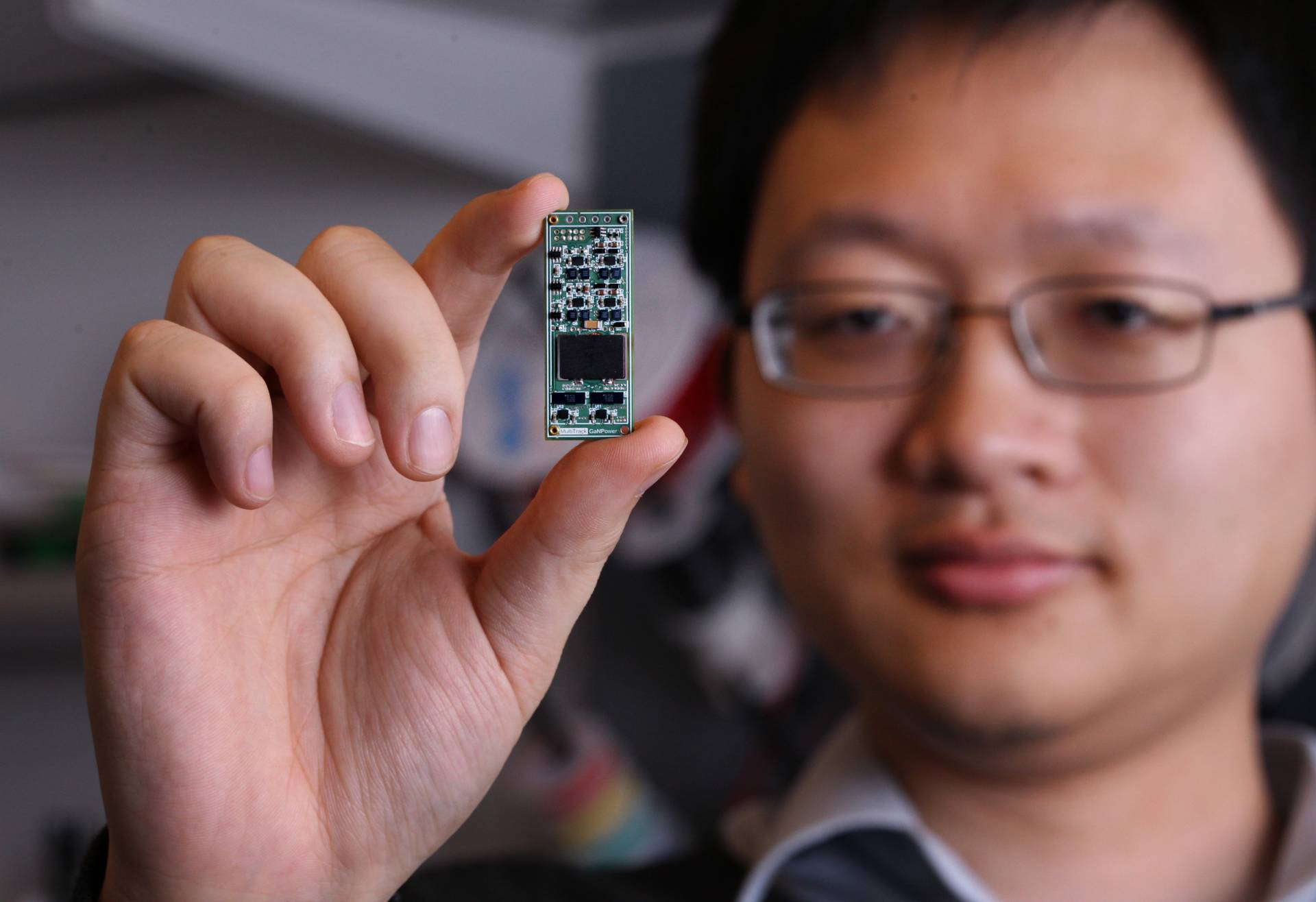 Minjie Chen holds a Power Converter chip 