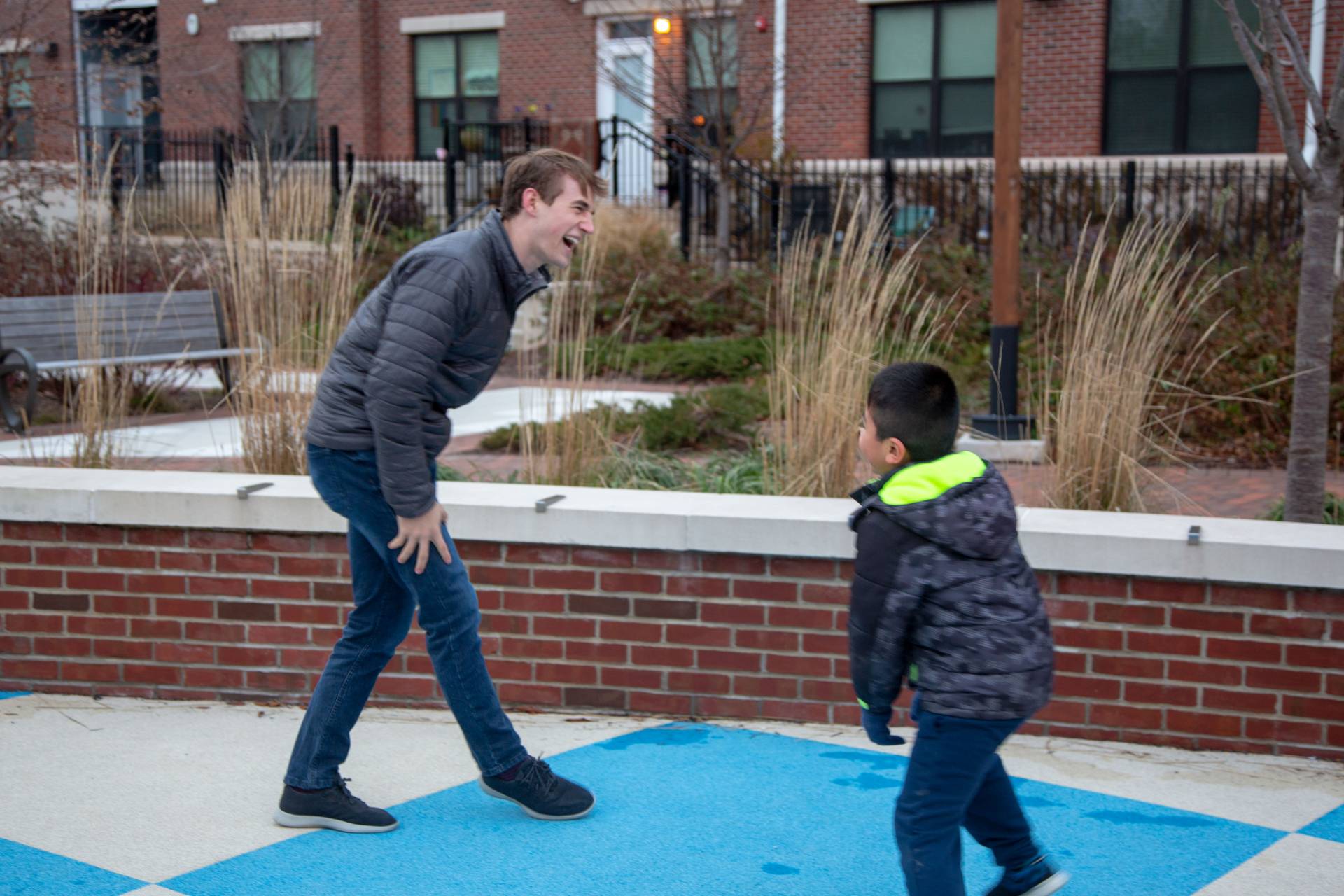 Student laughing with child on playground