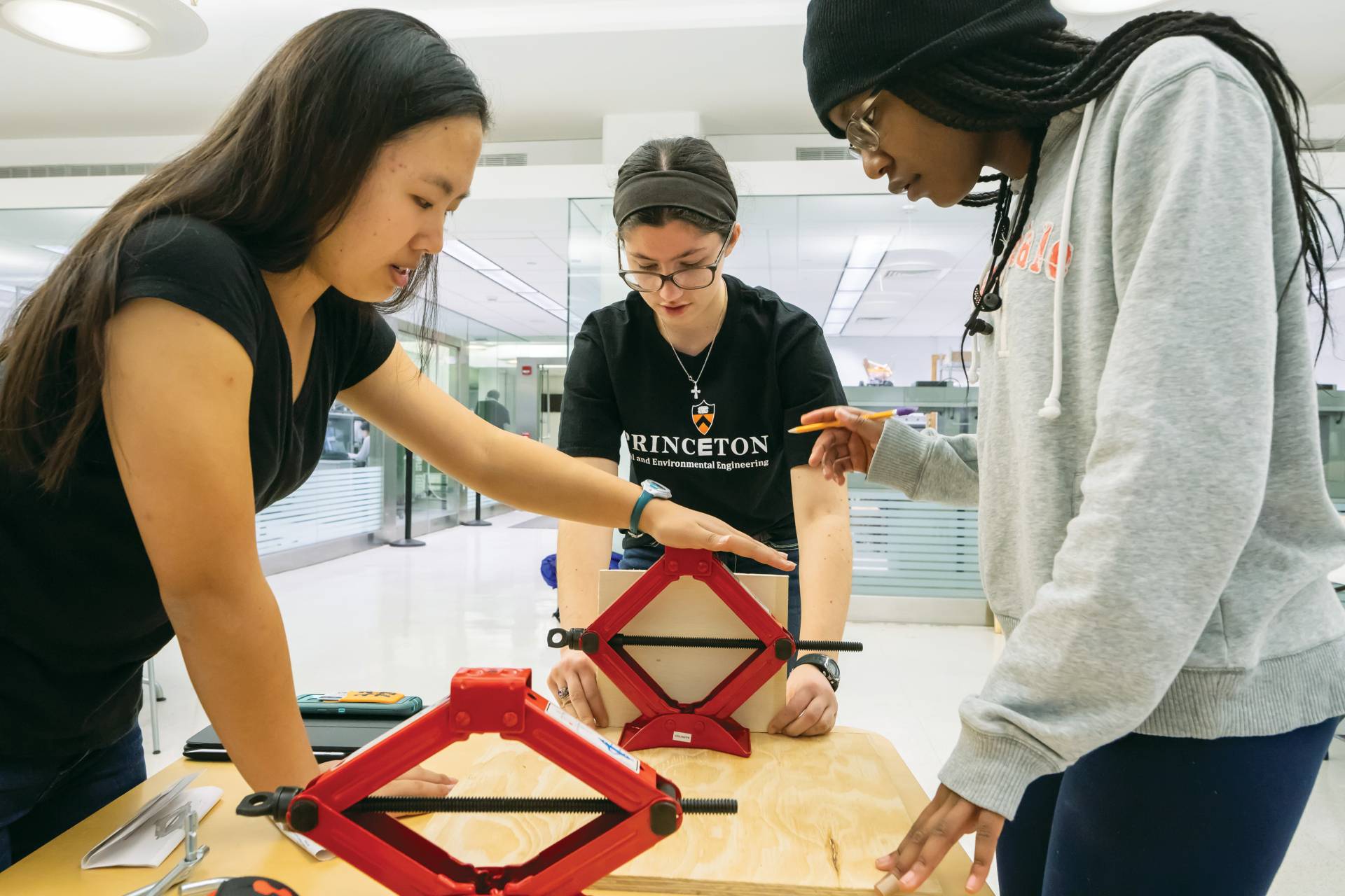 3 female students test an invention on a work table